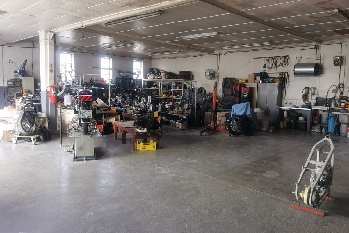 Spacious industrial garage or workshop area featuring concrete flooring, fluorescent lighting, and functional utility space suitable for automotive or storage use.