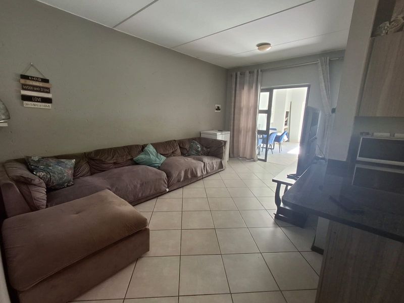 Open plan living area featuring tiled flooring and a sliding glass door providing access to an outdoor space.