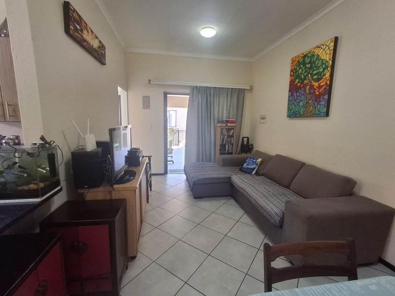 A living room area featuring tiled flooring and a sliding glass door providing access to an outdoor space.