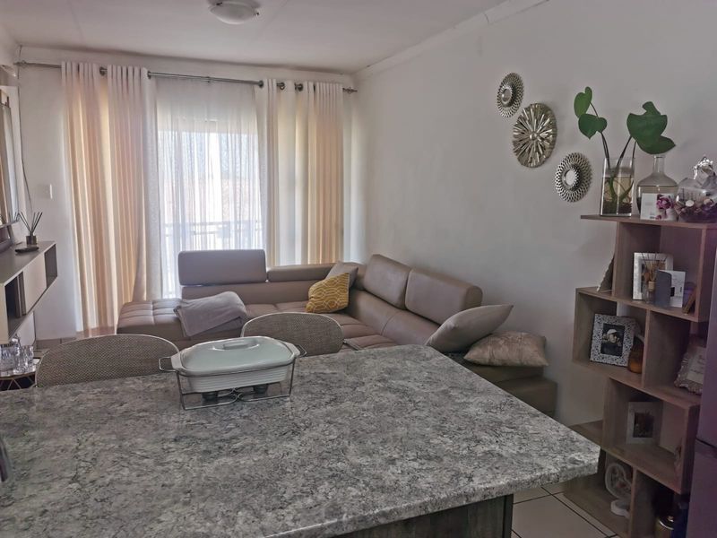 Open plan living area featuring tiled flooring, a granite kitchen island, and a sliding glass door providing access to the exterior.