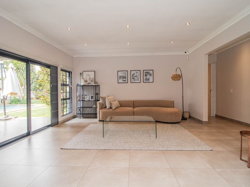 Spacious living room featuring large sliding glass doors that provide natural light and seamless access to the outdoor patio and pool area.