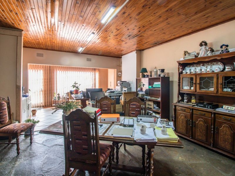 Spacious living area featuring a distinctive timber-clad ceiling, natural flagstone flooring, and large sliding doors providing access to the exterior.