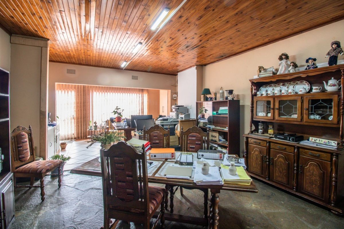Spacious living area featuring a distinctive timber-clad ceiling, natural flagstone flooring, and large sliding doors providing access to the exterior.