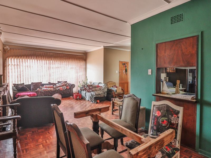 Open-plan living and dining area featuring traditional parquet flooring and a convenient serving hatch connecting to the kitchen space.