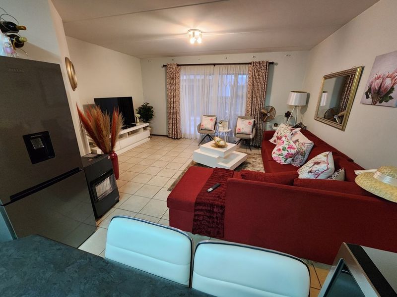 Open plan living area featuring tiled flooring and a sliding glass door providing access to the exterior.