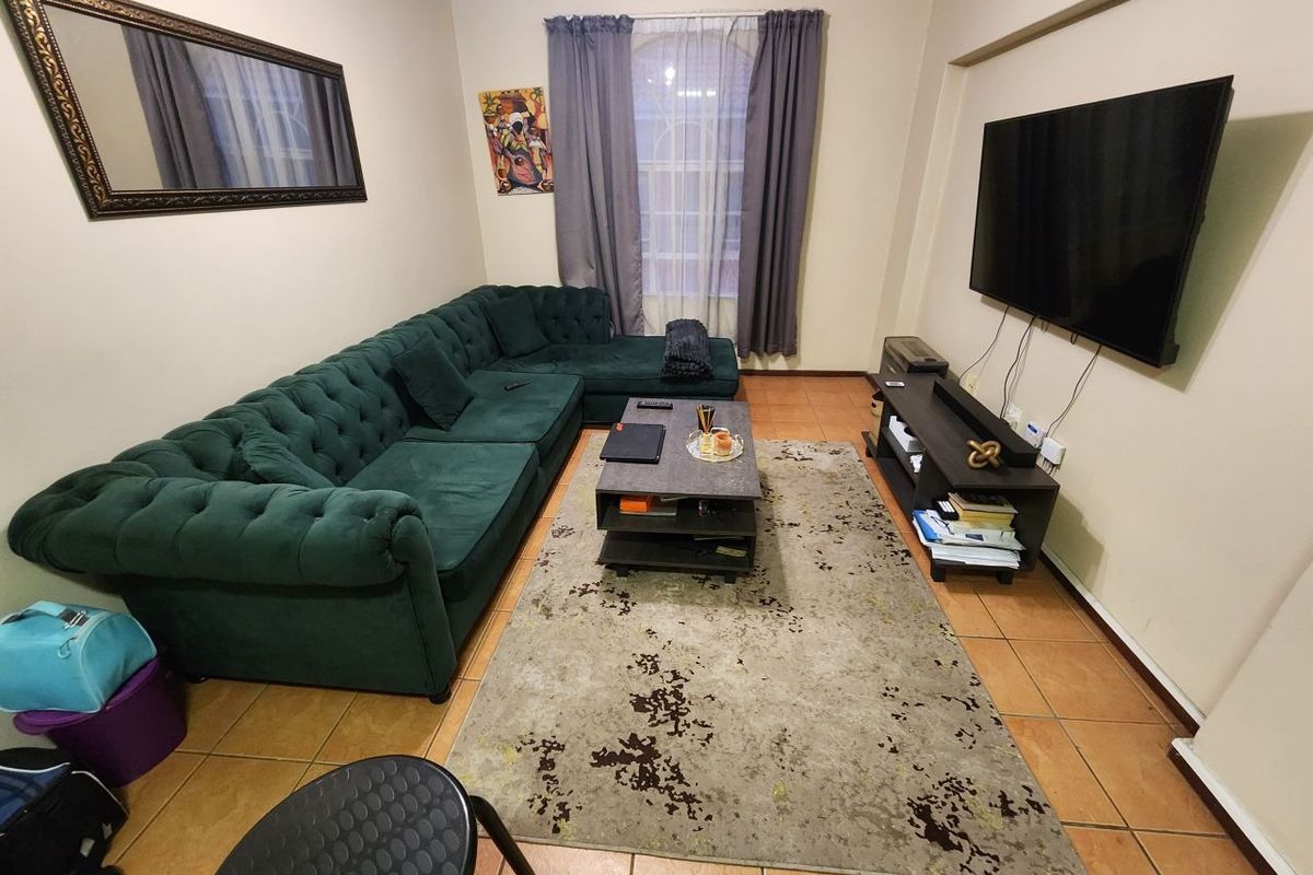 A comfortable living room featuring tiled flooring and neutral wall finishes, providing a functional space for relaxation and entertainment.