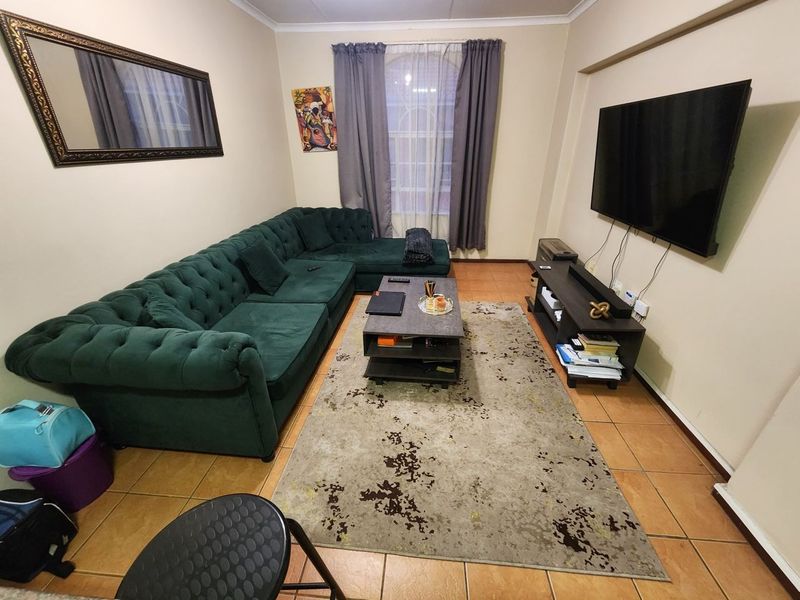 A comfortable living room featuring tiled flooring and neutral wall finishes, providing a functional space for relaxation and entertainment.