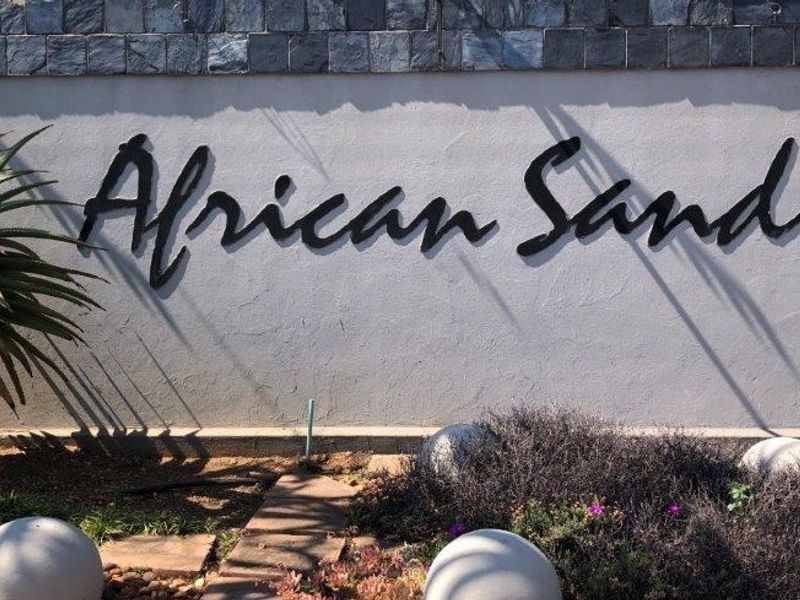 A clear view of the African Sands estate signage mounted on a plastered wall with stone cladding detail.