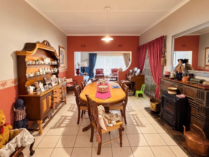 Spacious open-plan dining and living area featuring tiled flooring, a built-in fireplace, and a distinctive architectural archway connecting the two living spaces.