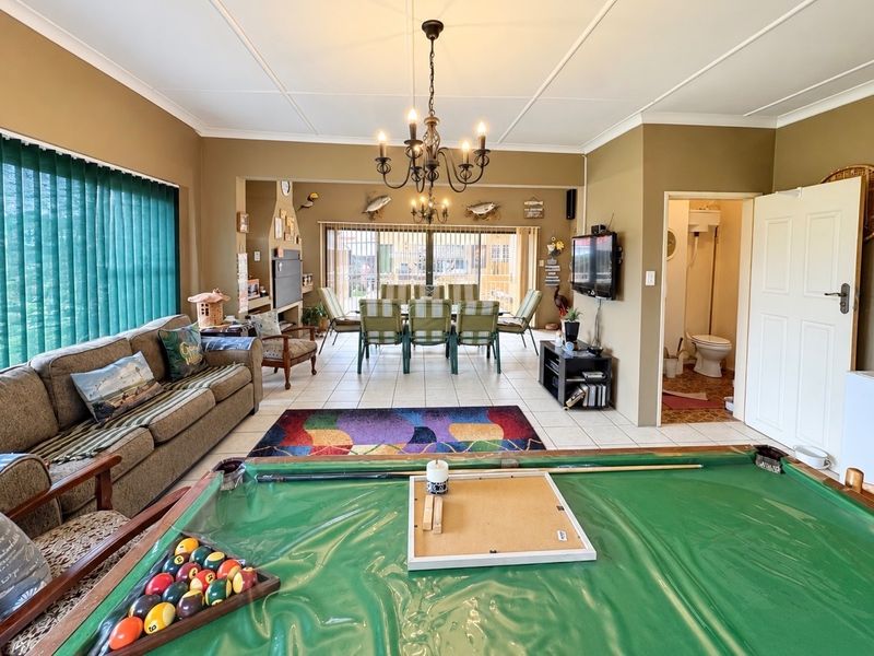 Spacious open-plan living and dining area featuring tiled floors, a built-in fireplace, and direct access to the outdoor patio through sliding glass doors.