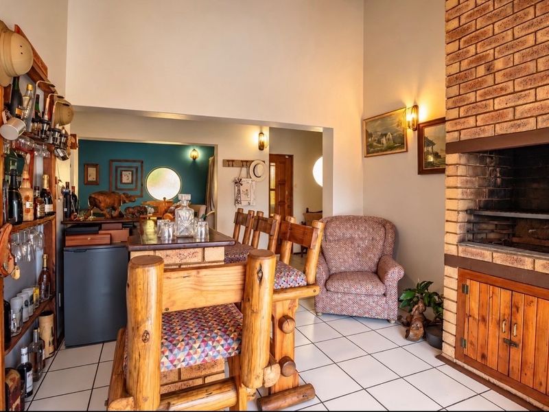 A living area featuring a built-in brick fireplace, tiled flooring, and a dedicated bar space with integrated counter.