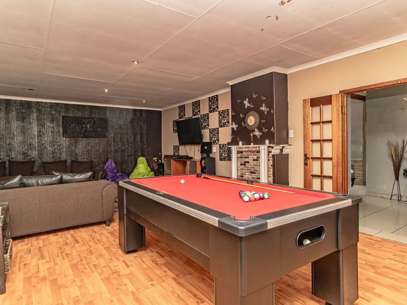 Spacious living area featuring a fireplace, laminate flooring, and recessed lighting, currently utilized as a recreational space.