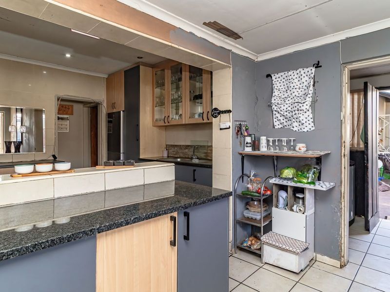 Kitchen featuring granite countertops, tiled backsplash, and built-in cabinetry, with direct access to an outdoor patio area.