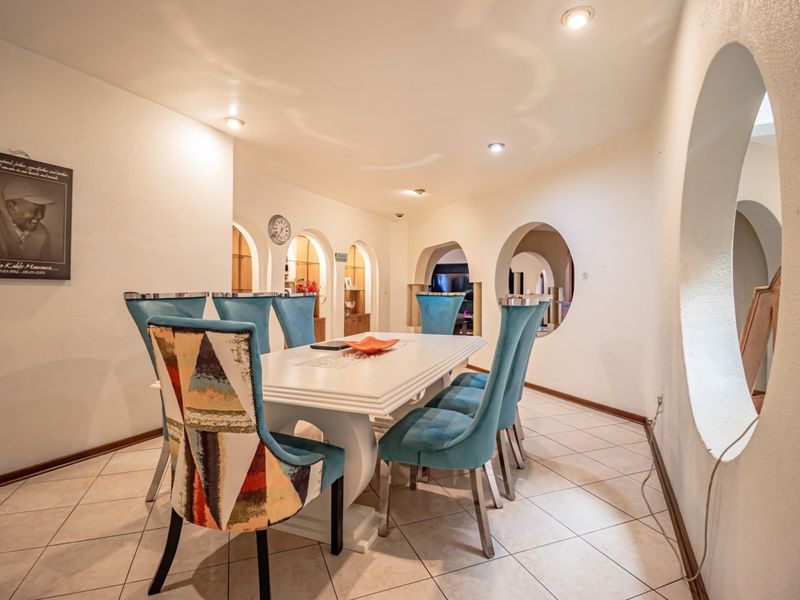 Dining room featuring ceramic tile flooring, recessed lighting, and unique architectural arched and circular wall cutouts connecting to adjacent living spaces.