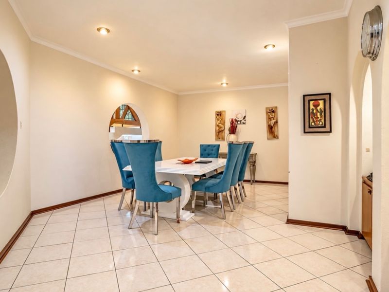 Spacious dining room featuring ceramic floor tiles, recessed lighting, and unique architectural archways connecting to adjacent living spaces.