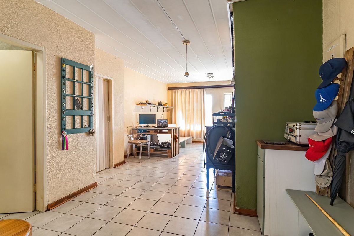 Open plan living area featuring tiled flooring and neutral wall finishes, providing a functional space with direct access to the exterior.