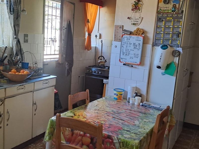 A functional kitchen featuring built-in cabinetry, a gas stove, and a tiled backsplash, offering potential for modernization and cosmetic updates.