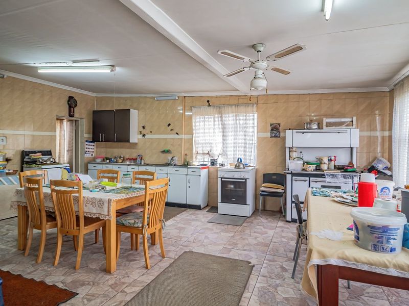 Spacious kitchen featuring tiled walls and flooring, built-in cabinetry, and a functional layout with ample space for dining.