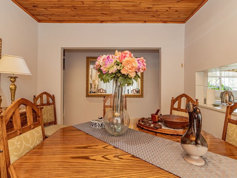 Dining room featuring a warm timber tongue and groove ceiling and a convenient pass-through window connecting to the kitchen area.