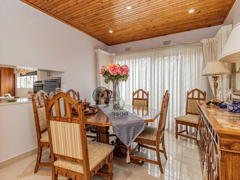 Dining room featuring tiled flooring, a timber tongue and groove ceiling with recessed lighting, and a convenient serving hatch connecting to the kitchen.