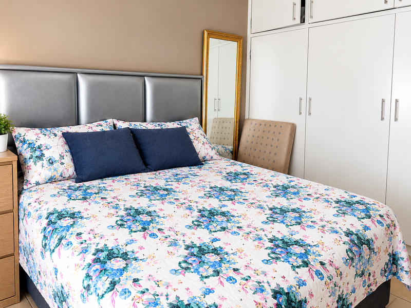 A well-maintained bedroom featuring ample built-in cupboard storage and a neutral wall finish.