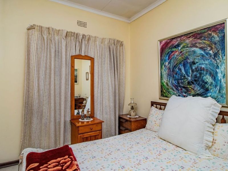 A standard bedroom featuring a built-in cupboard, neutral wall finishes, and a ventilation grille, offering a functional space ready for modern updates.