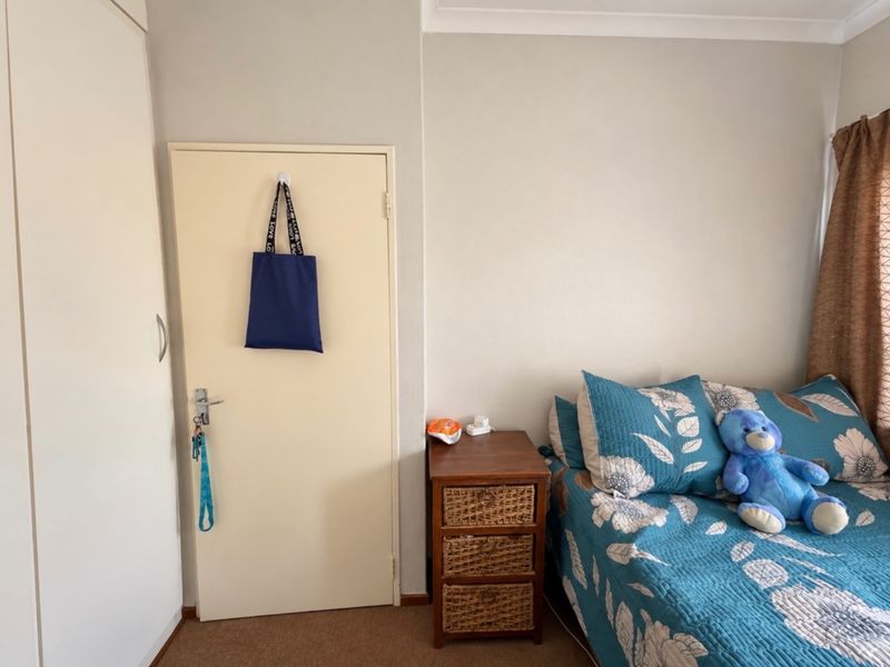 A bedroom featuring carpet flooring, a built-in wardrobe, and neutral wall finishes, providing a functional and comfortable living space.