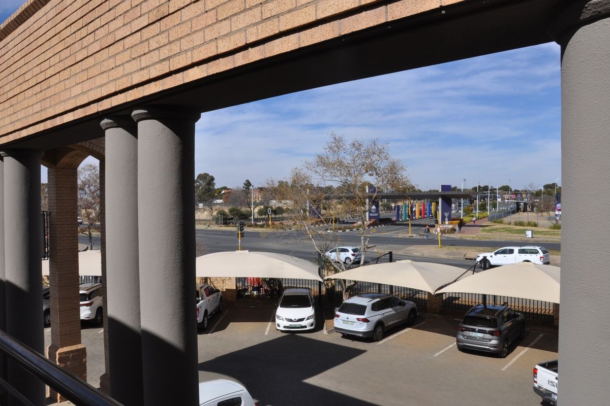 An elevated view from the office building overlooking the parking area with shade cloth carports and the surrounding street infrastructure.