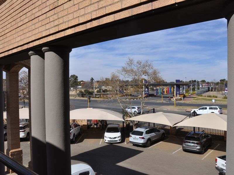 An elevated view from the office building overlooking the parking area with shade cloth carports and the surrounding street infrastructure.