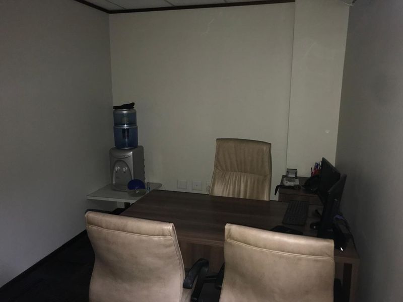 A compact office space featuring a suspended ceiling and neutral wall finishes, suitable for a private workspace or meeting room.