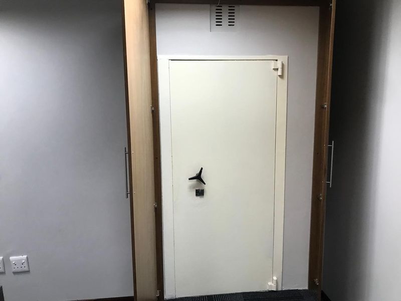 A secure office space featuring a built-in heavy-duty safe door integrated into the wall structure.
