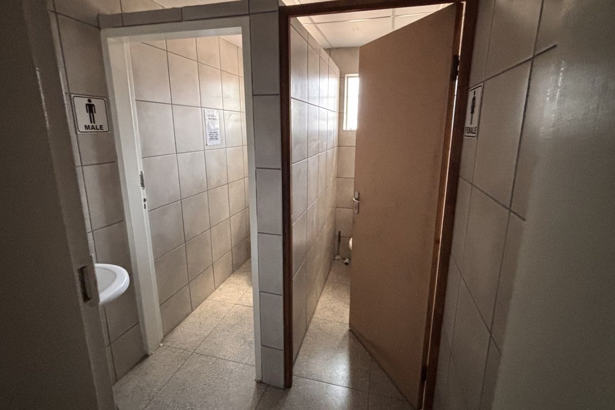 Industrial facility bathroom area featuring separate male and female access points with tiled walls and floors and basic wash basin fixtures.