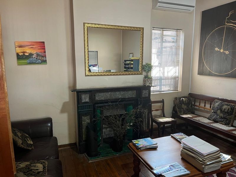 Office space featuring a decorative marble fireplace, timber flooring, and a wall-mounted air conditioning unit.