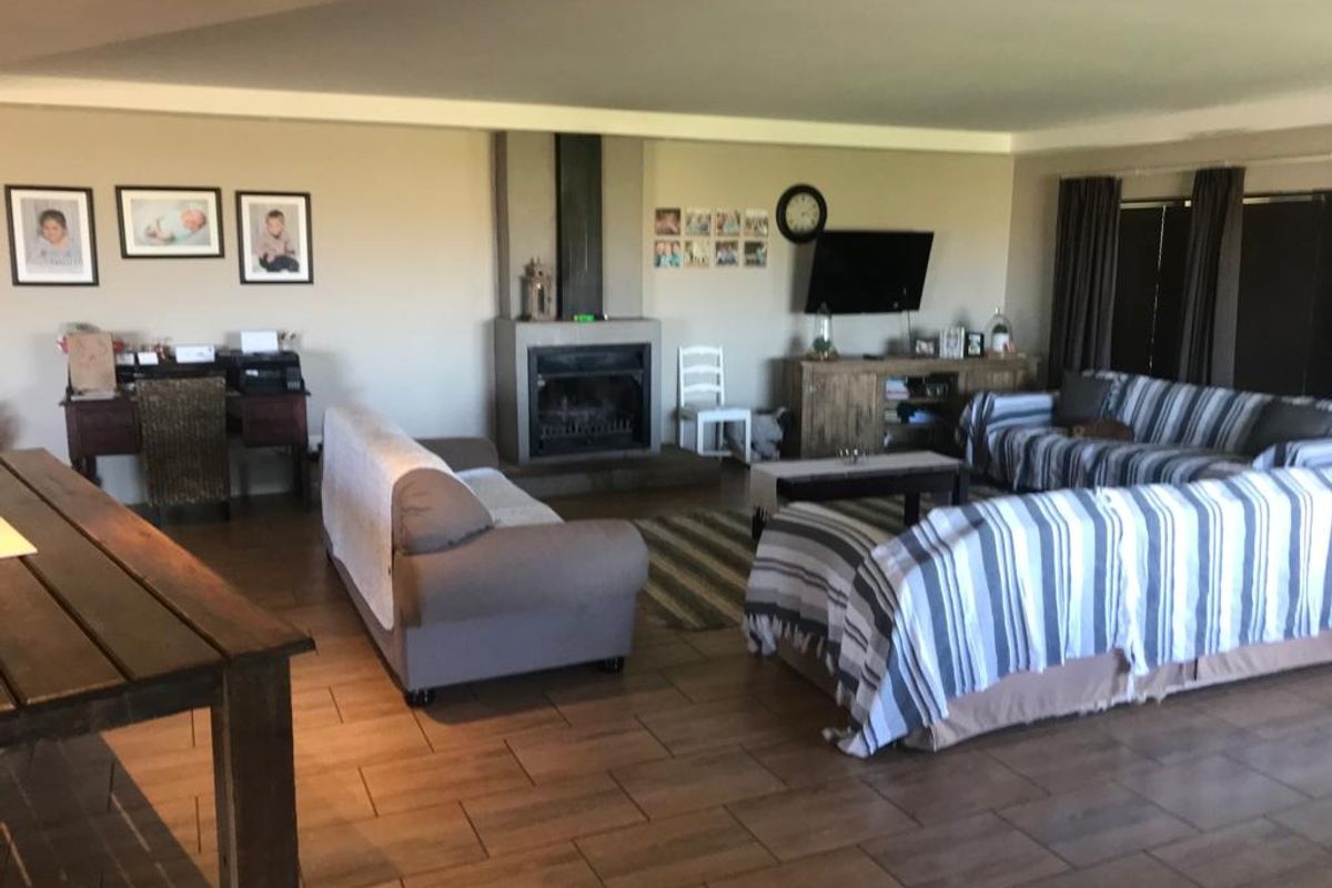 Spacious living room featuring tiled flooring and a central built-in fireplace, offering a comfortable and functional family living space.