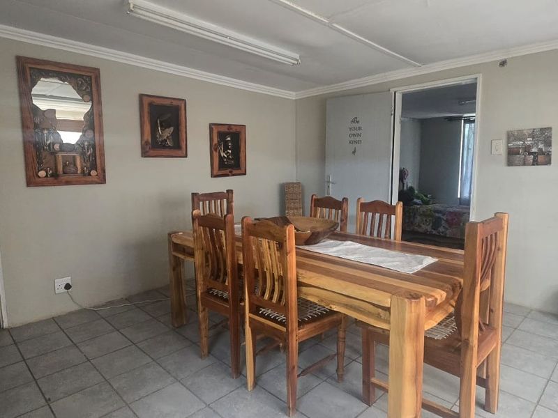 Dining area featuring tiled flooring and fluorescent lighting, providing access to adjacent rooms within the industrial property.