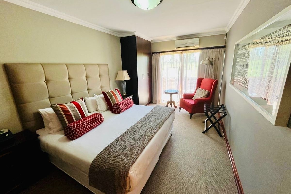 A well-maintained bedroom featuring a built-in wardrobe, split-system air conditioning, and sliding glass doors providing access to an outdoor area.