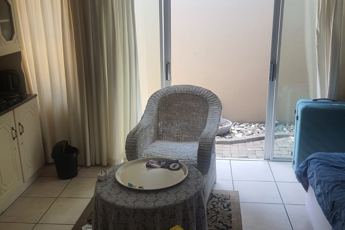Bedroom featuring tiled flooring and a sliding glass door providing access to a small private courtyard area.