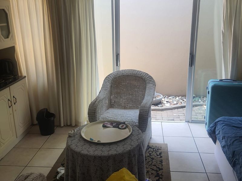 Bedroom featuring tiled flooring and a sliding glass door providing access to a small private courtyard area.