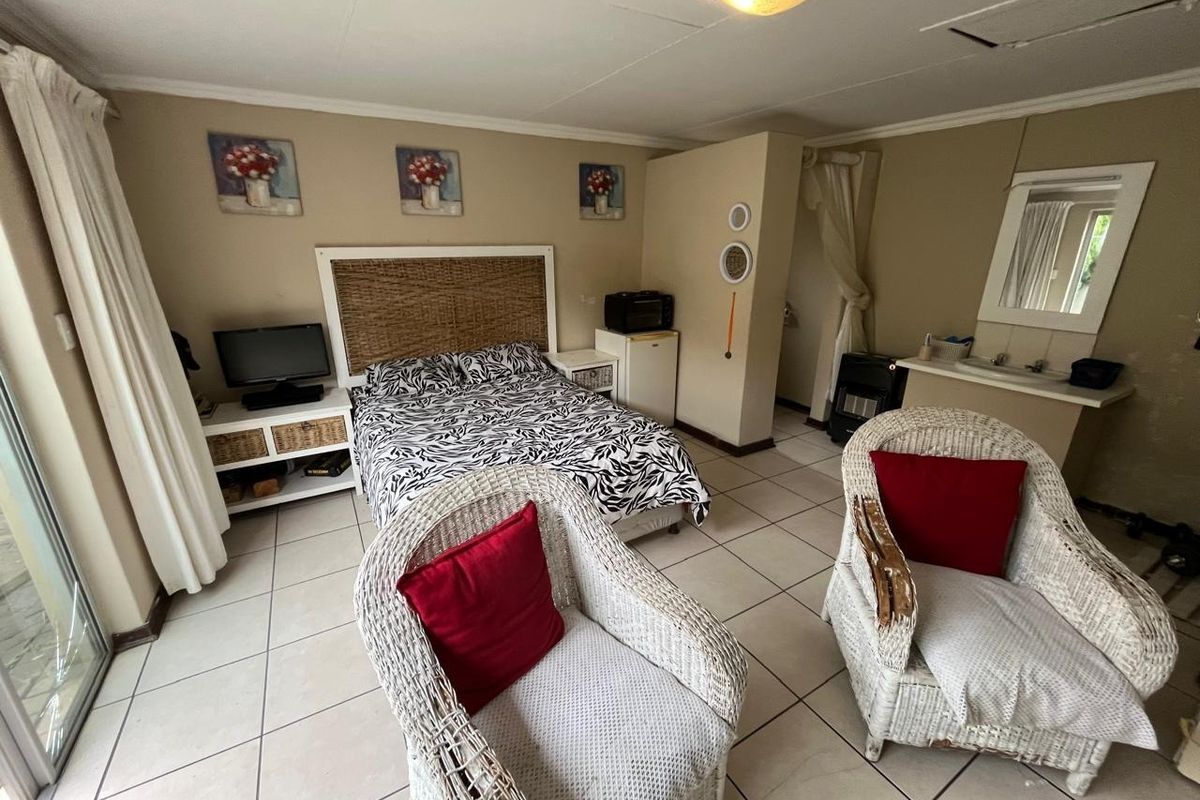 A bedroom featuring tiled flooring and a built-in vanity area, offering a functional layout with neutral wall tones.