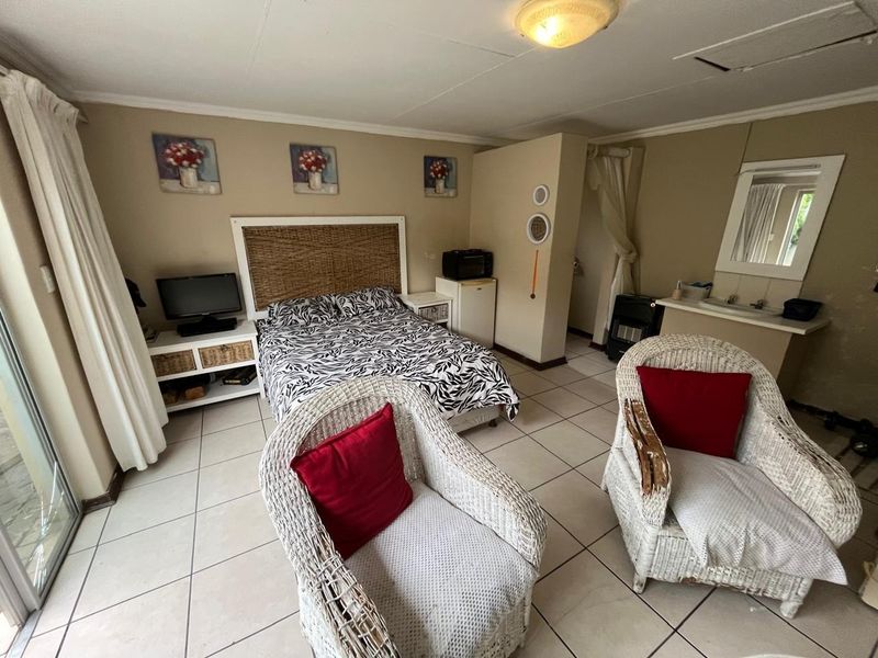A bedroom featuring tiled flooring and a built-in vanity area, offering a functional layout with neutral wall tones.