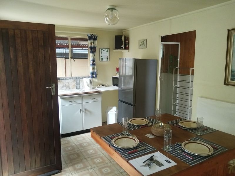 Open plan living and kitchen area featuring tiled flooring, functional cabinetry, and direct access to the exterior.