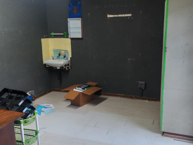 A utility space featuring a wall-mounted basin, timber ceiling, and split-system air conditioning, currently vacant and ready for renovation.