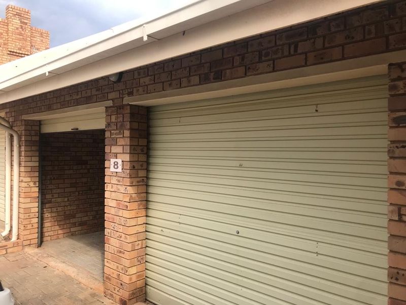 A functional double garage featuring brick construction and roller doors, providing secure parking and storage space.