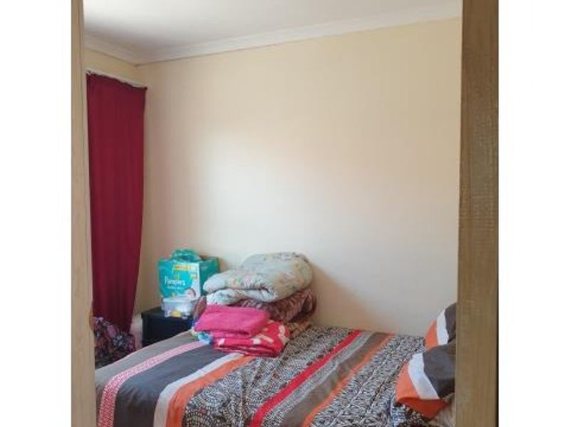 A standard bedroom featuring neutral wall finishes and coving, viewed through a doorway.