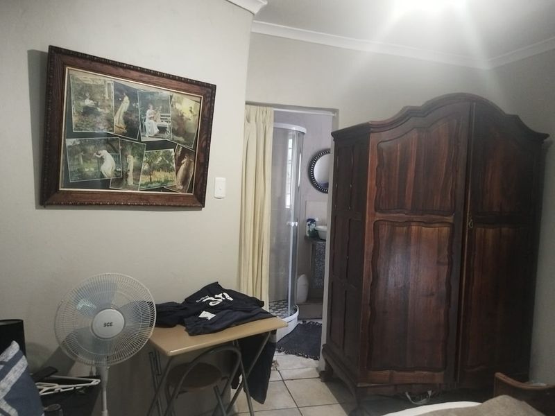 A bedroom featuring tiled flooring and coved ceilings, with direct access to an en-suite bathroom area.