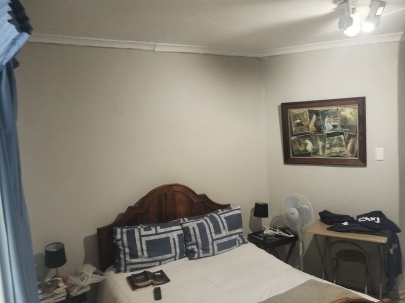 A functional bedroom featuring neutral wall finishes and ceiling-mounted lighting, suitable for guest accommodation.