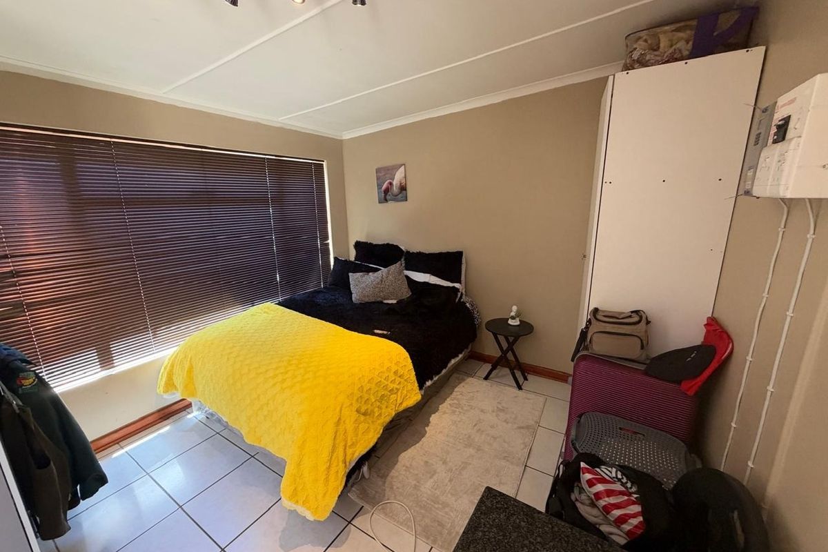A bedroom featuring tiled flooring, venetian blinds, and a built-in cupboard. The room includes an exposed electrical distribution board and requires minor maintenance.