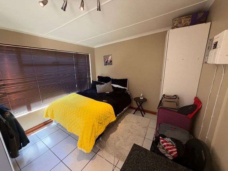 A bedroom featuring tiled flooring, venetian blinds, and a built-in cupboard. The room includes an exposed electrical distribution board and requires minor maintenance.