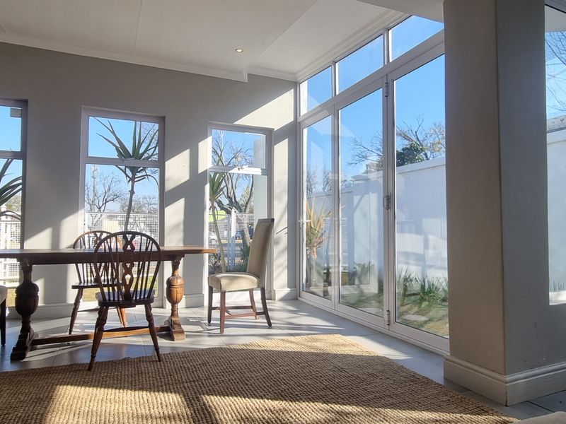 Bright and airy living space featuring large glass sliding doors, tiled flooring, and ample natural light, creating a seamless connection to the outdoor area.