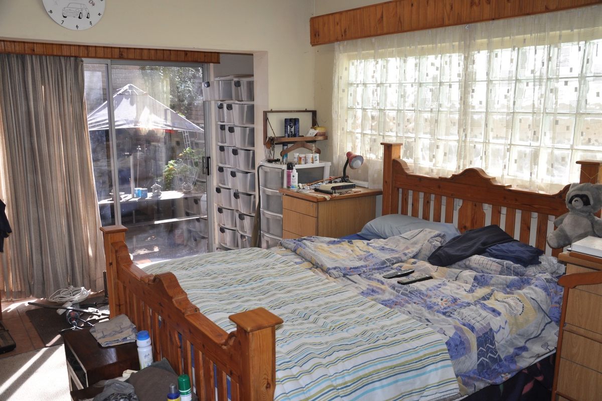 Bedroom featuring a sliding glass door leading to an outdoor area and a large glass block window, providing natural light.